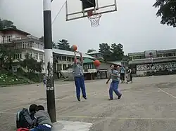 Schoolgirls shooting hoops among the Himalayas in Dharamsala, India.