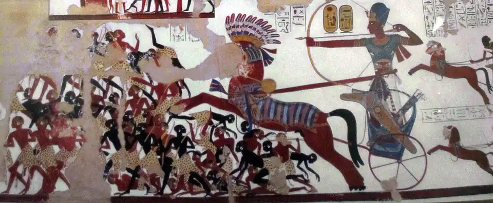 Ramesses II in his war chariot charging into battle against the Nubians. New Kingdom reliefs as seen in Rameses II temple, Beit el-Wali, represented Nubians with dark reddish brown and jet black skin tones.[242]